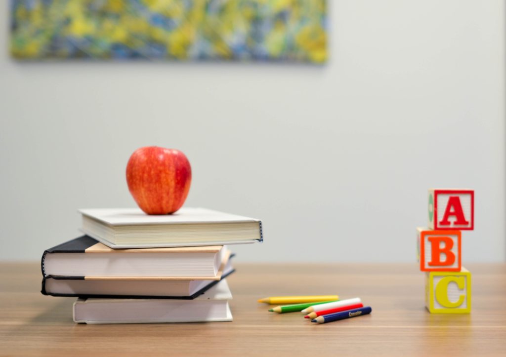 Desktop with books and apple.